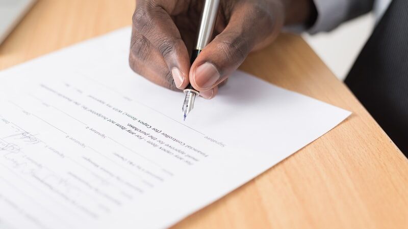 Firma de un documento sobre la mesa del despacho